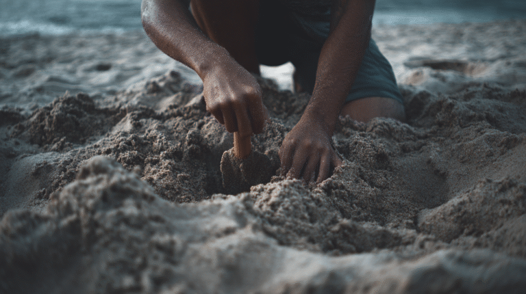 Person digging in the sand on a beach using both hands, with close-up focus on their arms and hands—exploring tips for finding gold in saltwater.